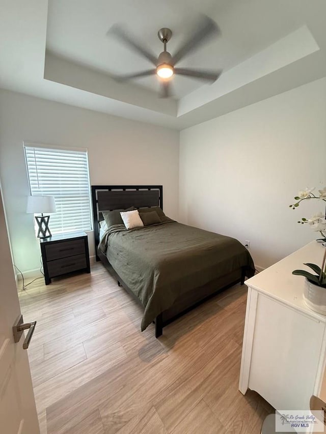 1992 Lulu St, Brownsville, TX 78577 - bedroom featuring a raised ceiling, a ceiling fan, and light wood-type flooring