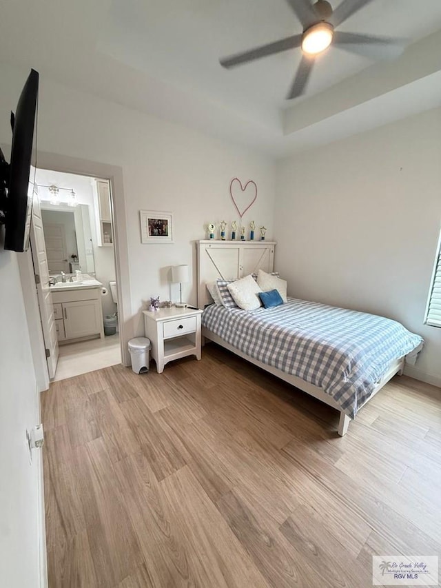 1992 Lulu St, Brownsville, TX 78577 - bedroom with light wood finished floors, a raised ceiling, ensuite bathroom, and ceiling fan