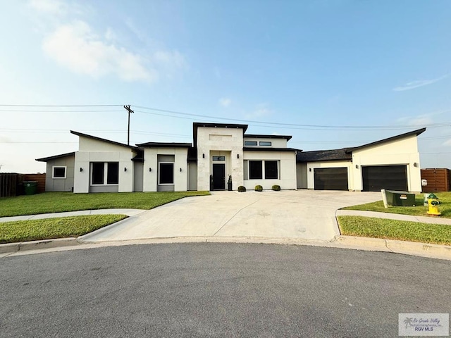 1992 Lulu St, Brownsville, TX 78577 - view of front facade featuring concrete driveway, an attached garage, a front lawn, and stucco siding
