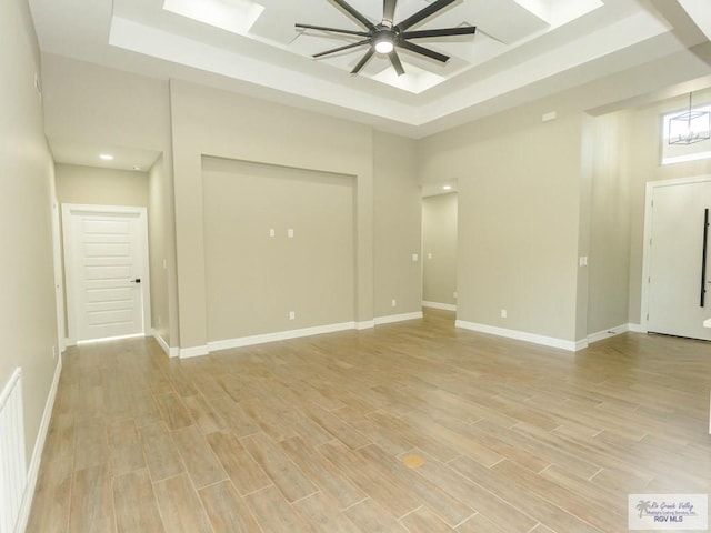 empty room with a raised ceiling and ceiling fan