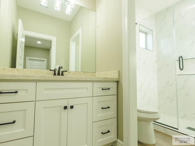 bathroom with hardwood / wood-style flooring, vanity, an enclosed shower, and toilet