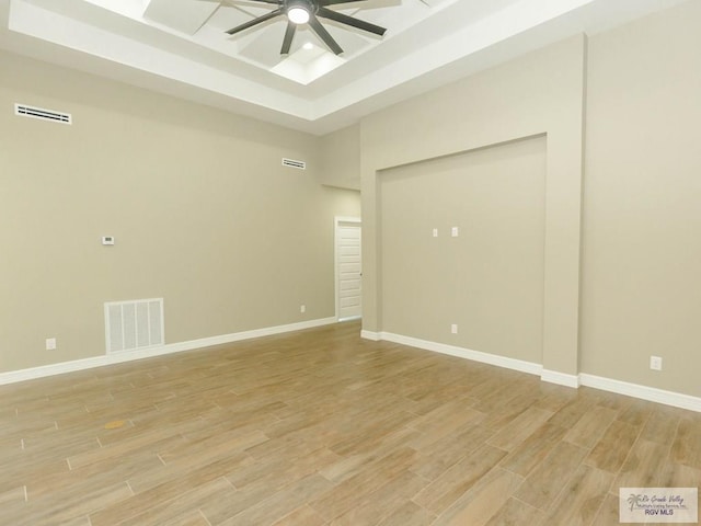 spare room featuring a raised ceiling and ceiling fan