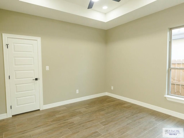 unfurnished room featuring a tray ceiling and ceiling fan