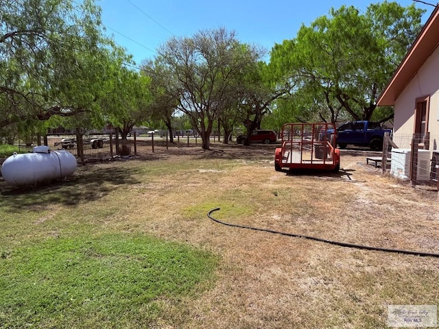 view of yard with central AC unit and fence