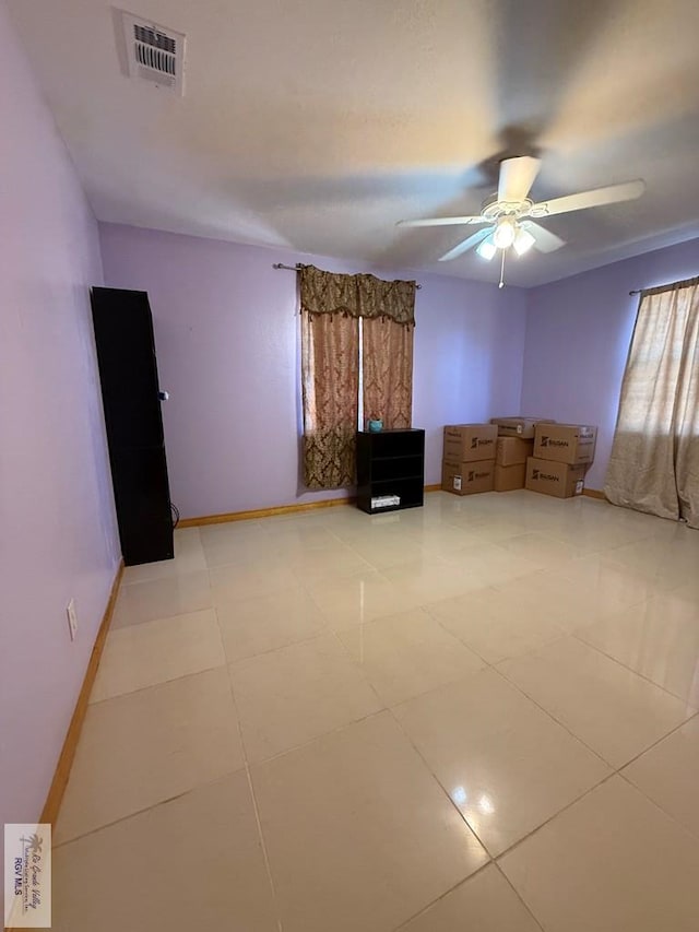 spare room with visible vents, baseboards, and a ceiling fan