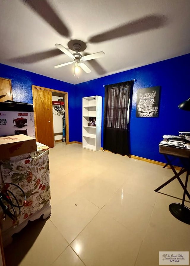 interior space featuring baseboards and a ceiling fan