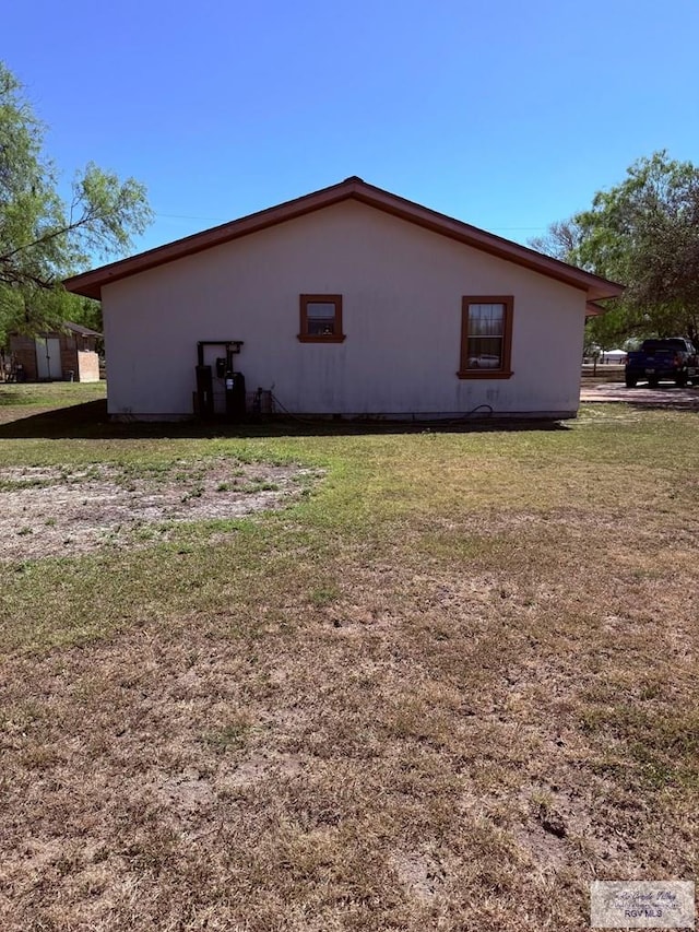 view of side of home with a yard