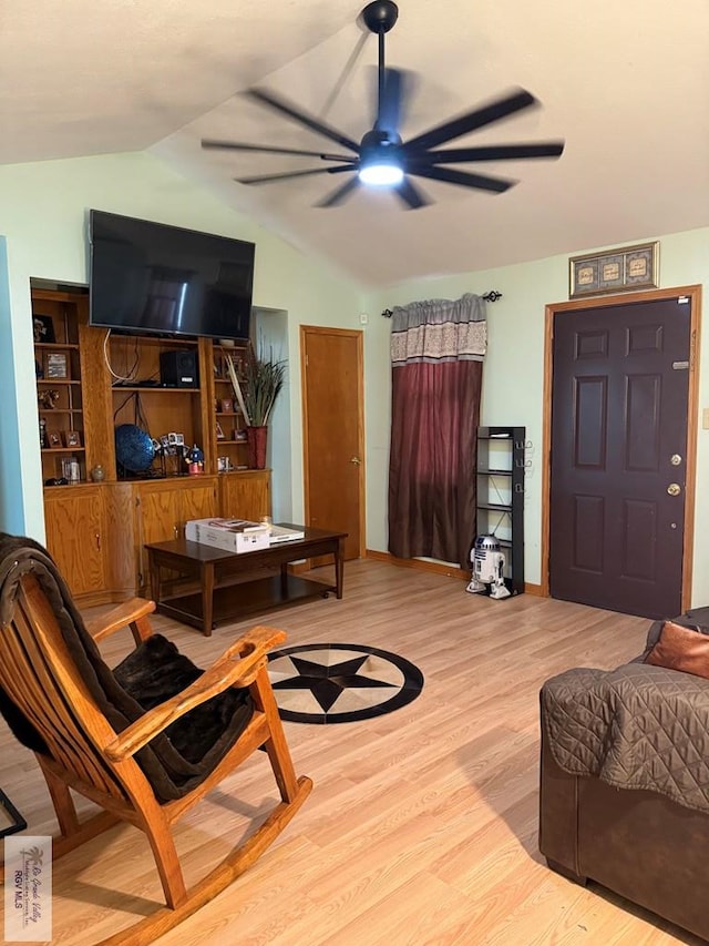 living area featuring lofted ceiling, ceiling fan, and wood finished floors