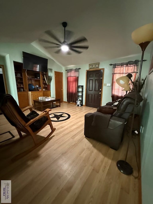 living area with vaulted ceiling, ceiling fan, and wood finished floors