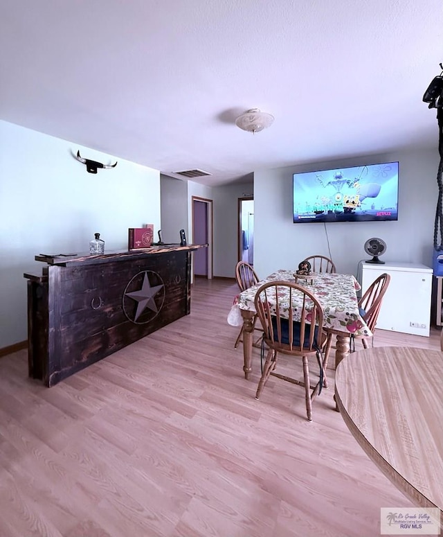 dining space featuring visible vents and light wood-style floors