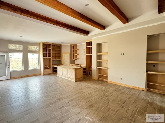 unfurnished living room featuring beam ceiling and hardwood / wood-style flooring