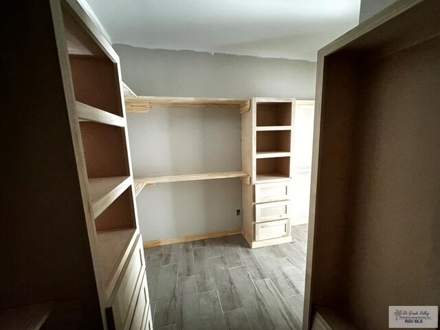 spacious closet featuring dark hardwood / wood-style flooring