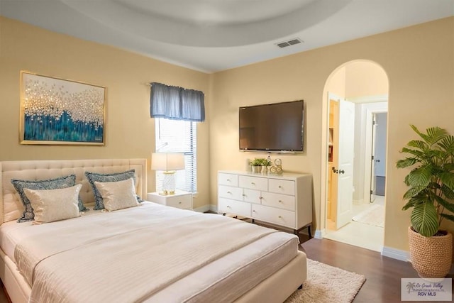 2410 E 21st St, Mission, TX 78572 - bedroom with wood finished floors, arched walkways, and baseboards