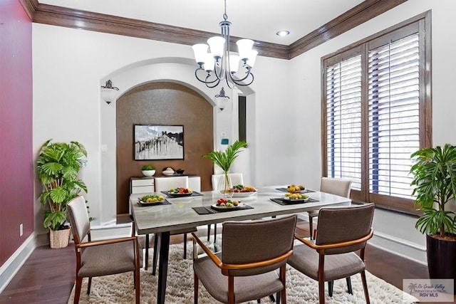 2410 E 21st St, Mission, TX 78572 - dining area featuring crown molding, baseboards, a chandelier, wood finished floors, and arched walkways