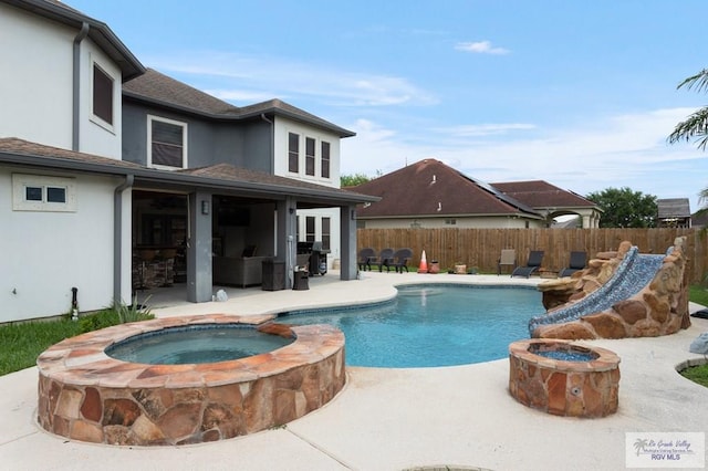 view of pool with an in ground hot tub, a patio area, and a grill