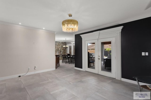 spare room with crown molding, french doors, and a chandelier