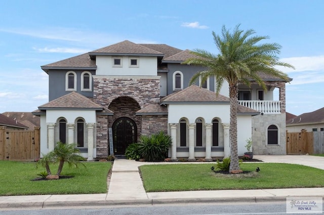 mediterranean / spanish home with a balcony and a front yard