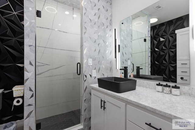 bathroom with vanity, walk in shower, and tile walls