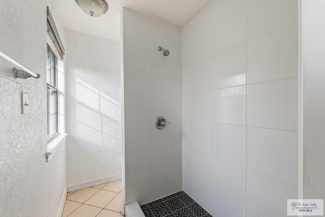 bathroom featuring tile patterned flooring and a tile shower