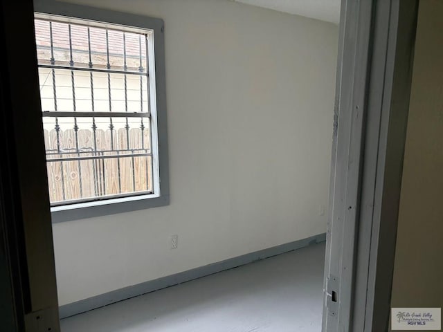 unfurnished room featuring baseboards