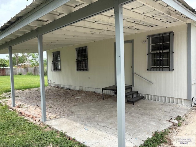 view of patio / terrace featuring entry steps, a carport, and fence