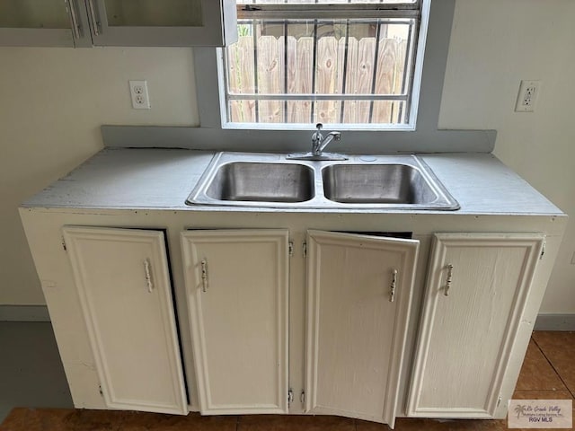kitchen with a wealth of natural light, tile patterned floors, a sink, and light countertops