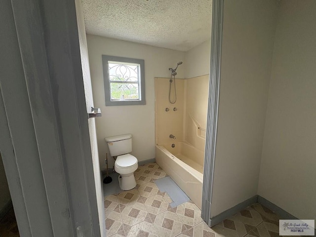 full bathroom with a textured ceiling, toilet, baseboards, and bathtub / shower combination