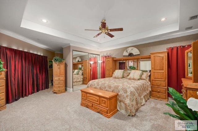 bedroom featuring a raised ceiling, crown molding, light colored carpet, and ceiling fan