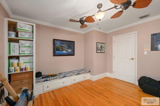 living area with crown molding, wood-type flooring, and ceiling fan