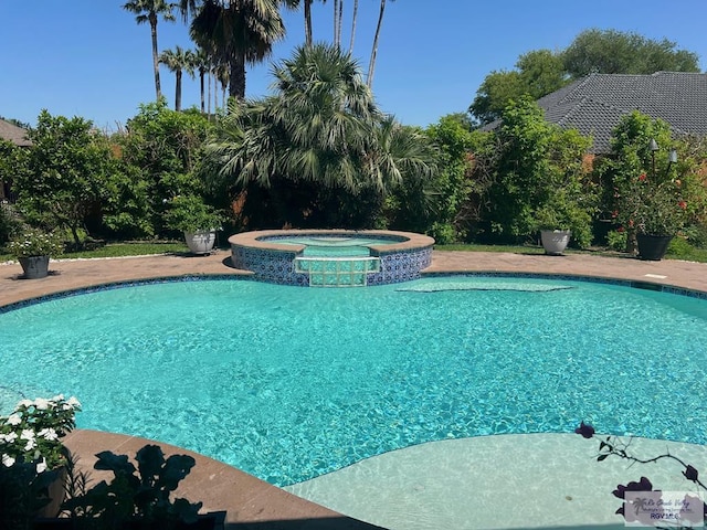 view of swimming pool with an in ground hot tub