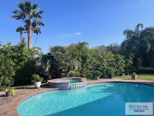 view of swimming pool featuring an in ground hot tub