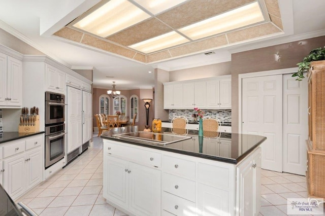 kitchen featuring light tile patterned flooring, a notable chandelier, a center island, and white cabinets