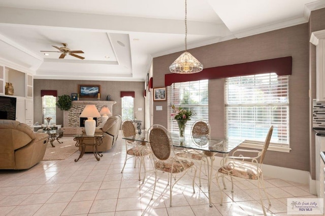 tiled dining space featuring crown molding, ceiling fan, and a tray ceiling