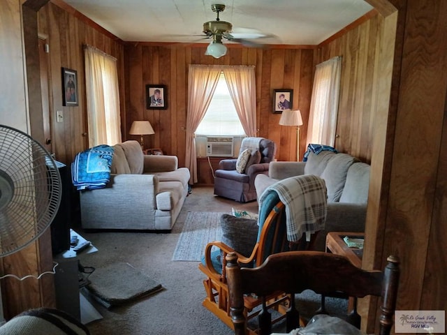 sitting room featuring ceiling fan, wooden walls, and carpet floors