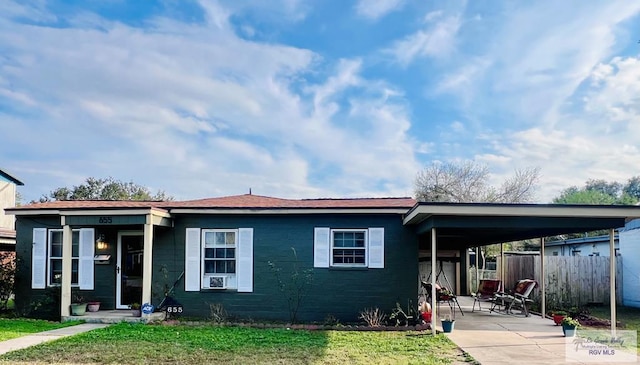 view of front of property featuring fence and an attached carport