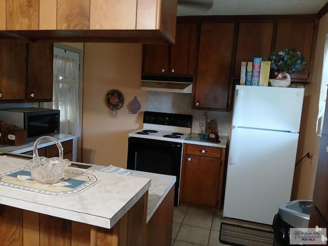 kitchen featuring white refrigerator, decorative backsplash, electric range oven, and light tile patterned floors