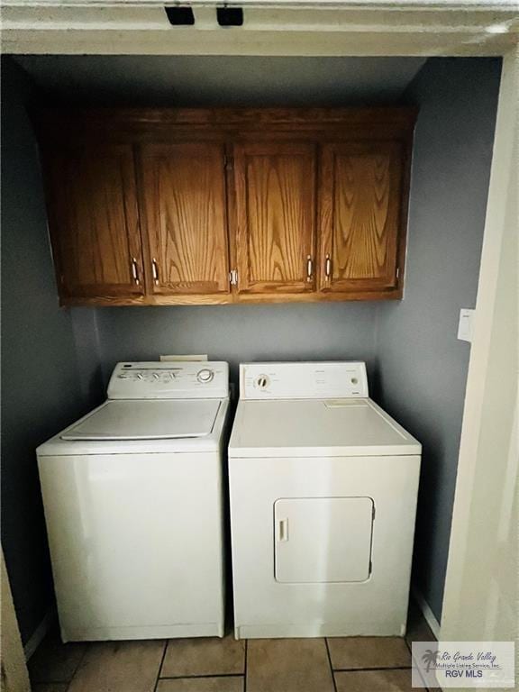 laundry area featuring tile patterned flooring, cabinet space, and washing machine and clothes dryer