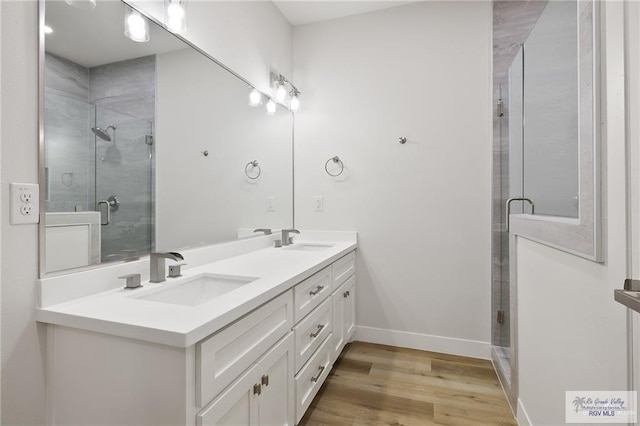 bathroom featuring vanity, a shower with shower door, and wood-type flooring