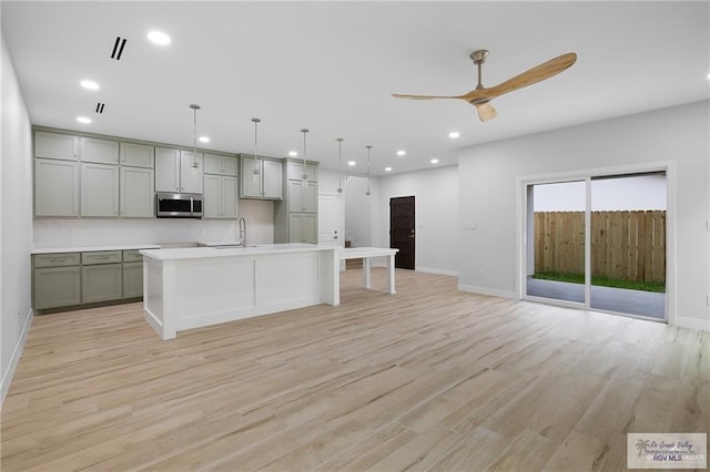 kitchen featuring pendant lighting, light hardwood / wood-style flooring, and ceiling fan