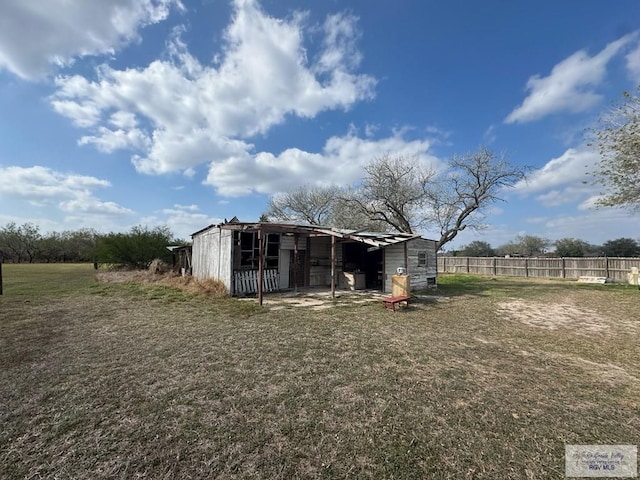 view of pole building featuring fence and a yard