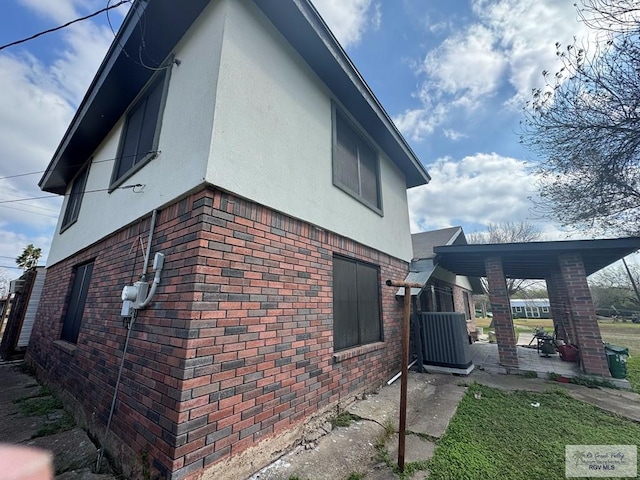 view of side of property with brick siding and stucco siding