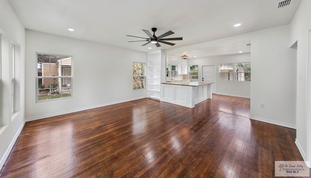 unfurnished living room with ceiling fan, built in features, and dark hardwood / wood-style floors