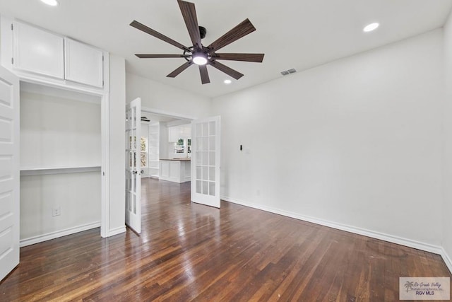 unfurnished room with ceiling fan, dark hardwood / wood-style floors, and french doors