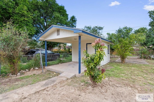 view of yard featuring a carport and an outbuilding