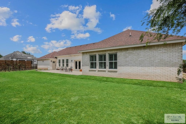 25142 Teal Cir, San Benito, TX 78586 - rear view of property with fence, a patio area, french doors, brick siding, and a lawn