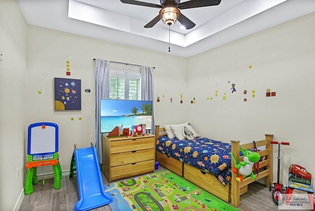 25142 Teal Cir, San Benito, TX 78586 - bedroom featuring a tray ceiling, a ceiling fan, wood finished floors, and baseboards