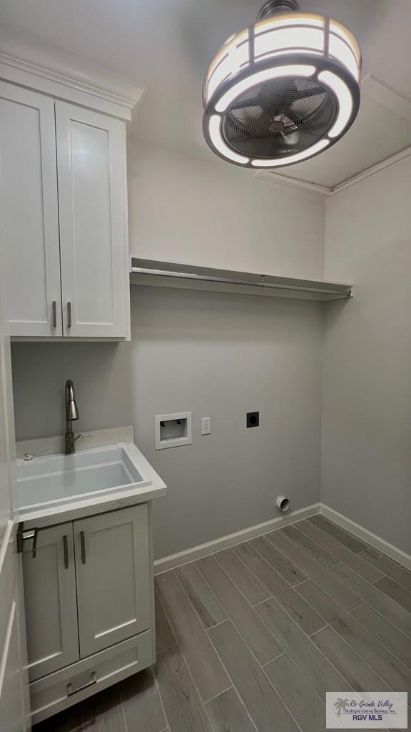 laundry room with electric dryer hookup, cabinets, sink, washer hookup, and dark hardwood / wood-style floors