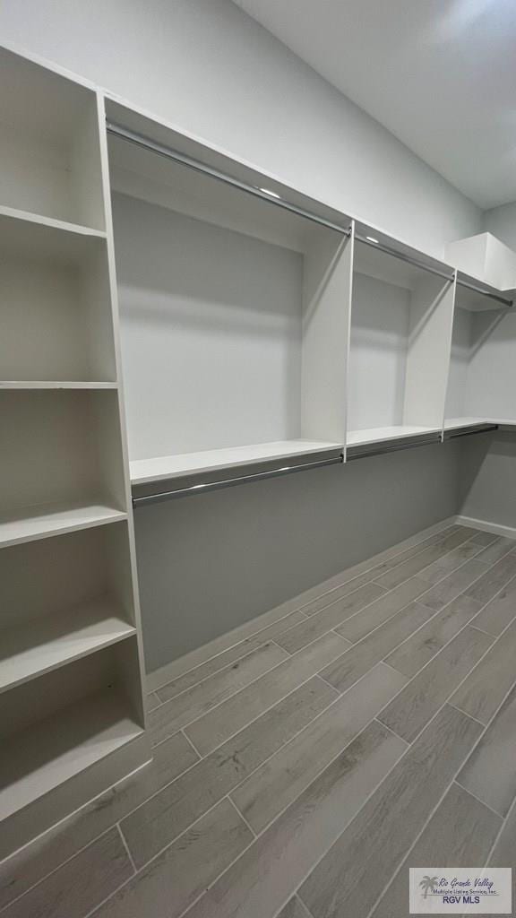 spacious closet with dark wood-type flooring