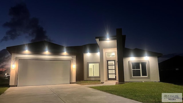 view of front of property with a garage and a lawn