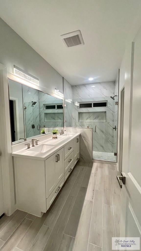 bathroom featuring wood-type flooring, vanity, and a shower with shower door